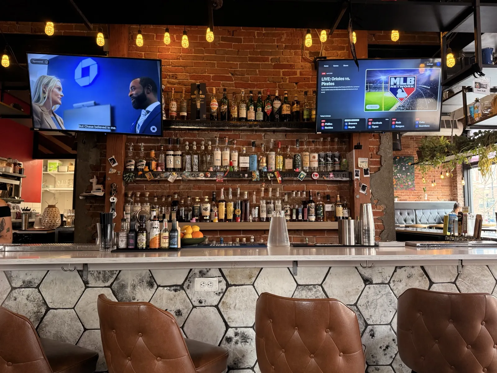 Interior view of MuNi KC showing the bar counter, back bar shelves with bottles, and warm ambient lighting
