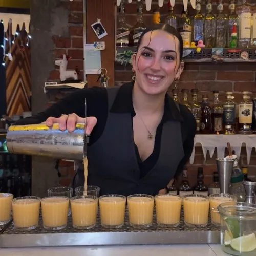 MuNi KC bartender pouring a row of shots behind the bar
